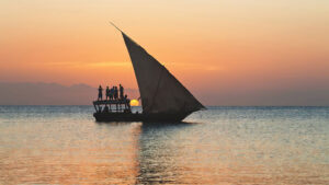 Sunset view from Zanzibar Island with traditional dhow boats on the horizon