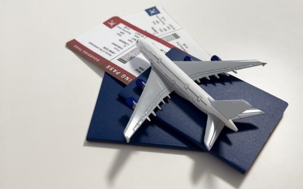 Boarding pass, passport and toy aircraft on a desk