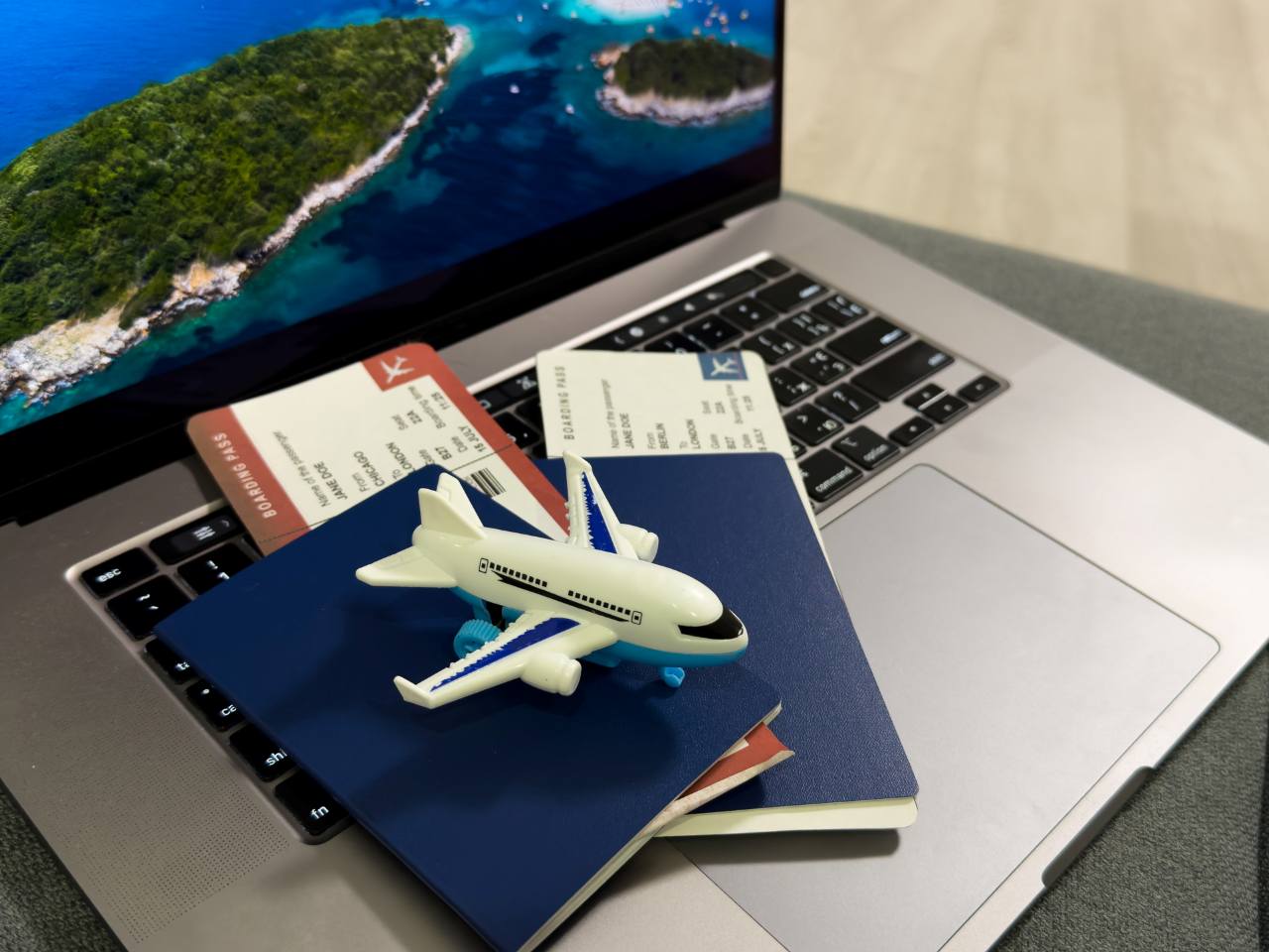toy airplane on top of passports, plane tickets and a laptop