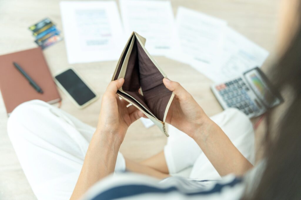 person looking at his empty wallet
