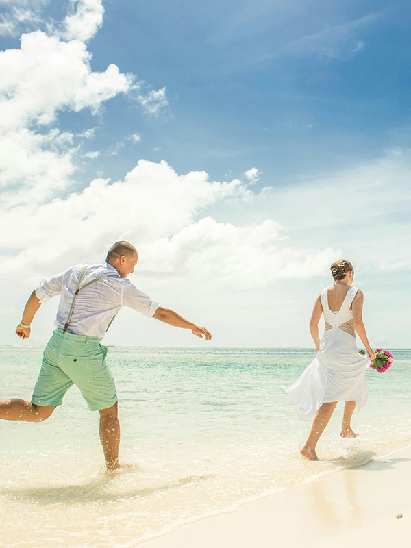 A romantic couple walking hand-in-hand along a pristine Zanzibar beach, honeymoon vibes
