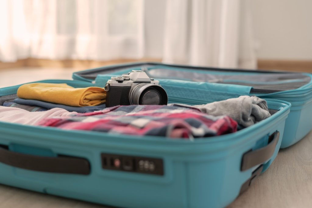 travel luggage with clothes and camera