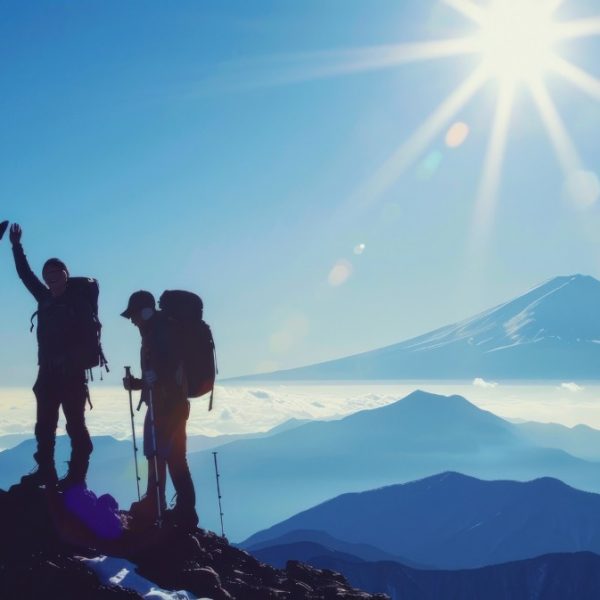 Mountaineer team reaching peak success with high five in mountain landscape