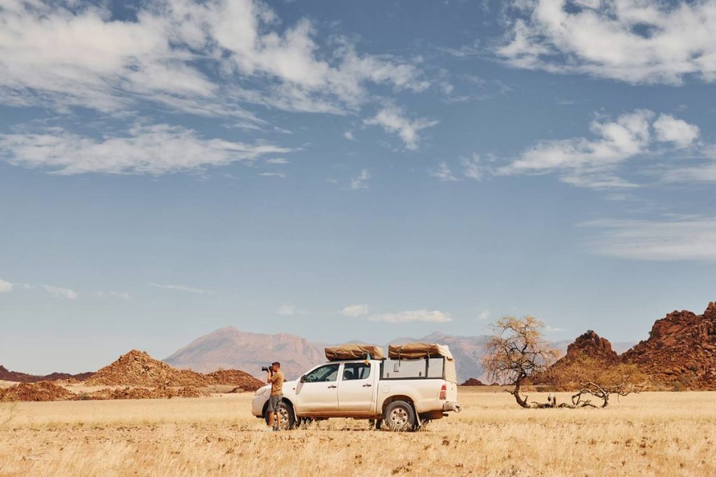 Photographer near car that is in the deserts