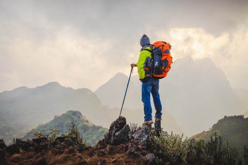 Man hiker on a top of a mountain, hiking in mountains